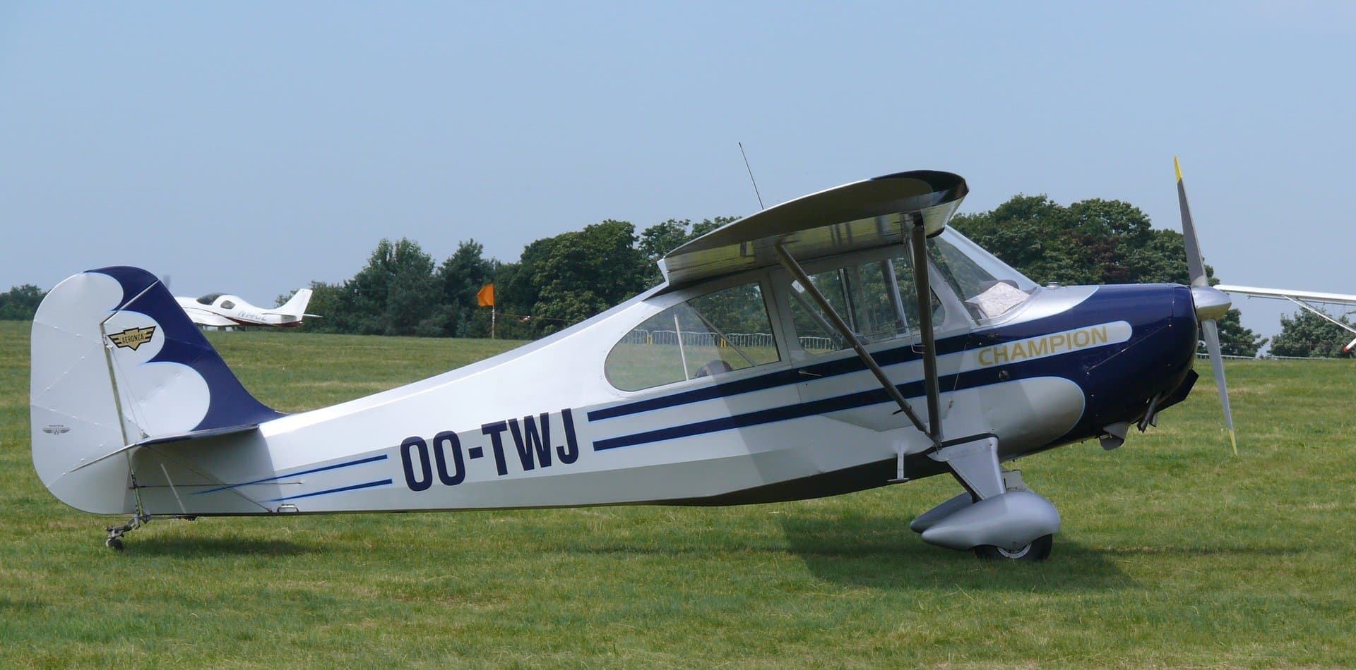 A yellow Aeronca 7AC Champion on the grass at Schaffen-Diest airfield, Belgium