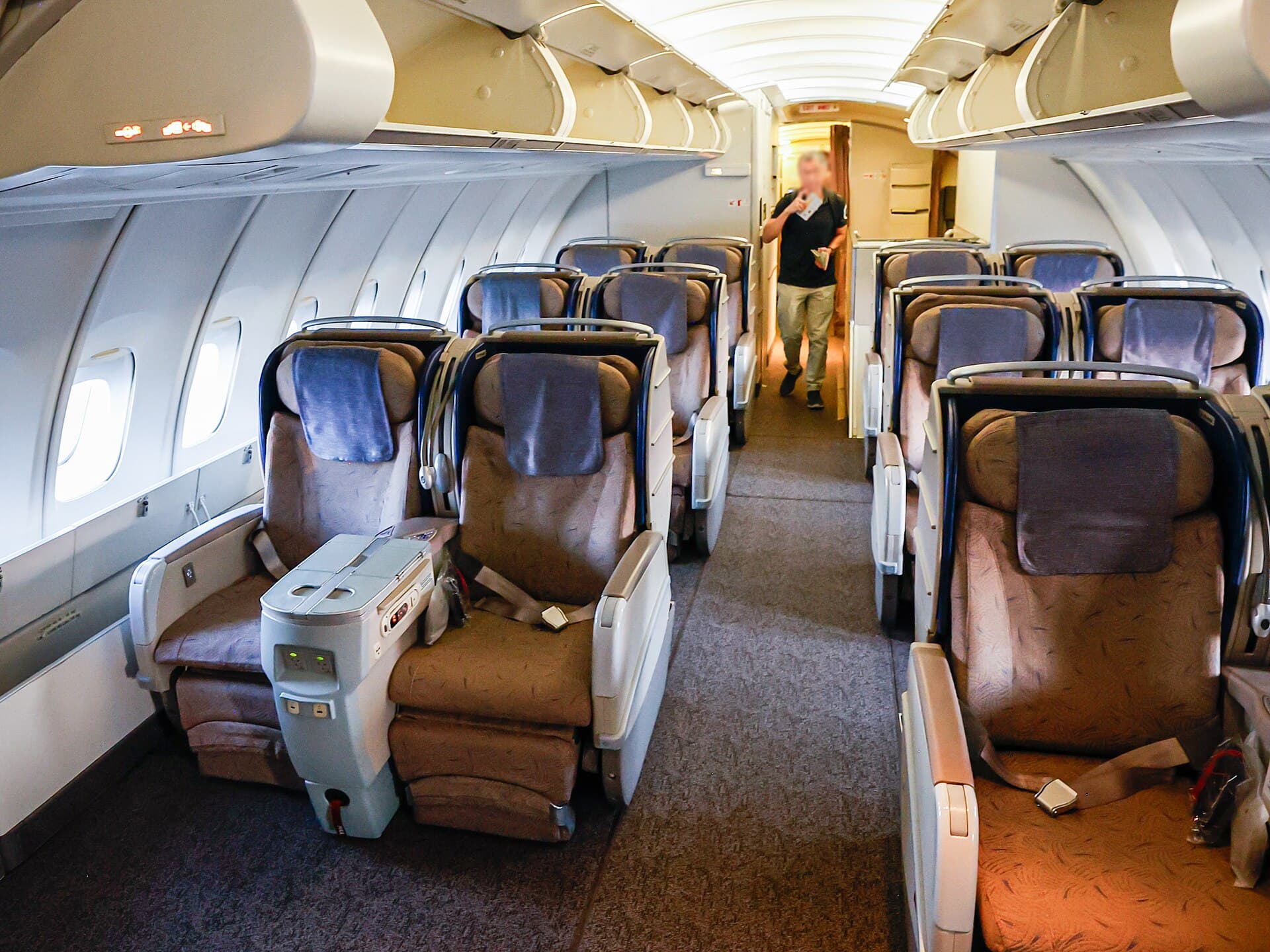 Une cabine économique à dix sièges de front à bord d'un Boeing 747-400 d'Asiana, des rangées de sièges bleus s'étirant vers la cloison arrière