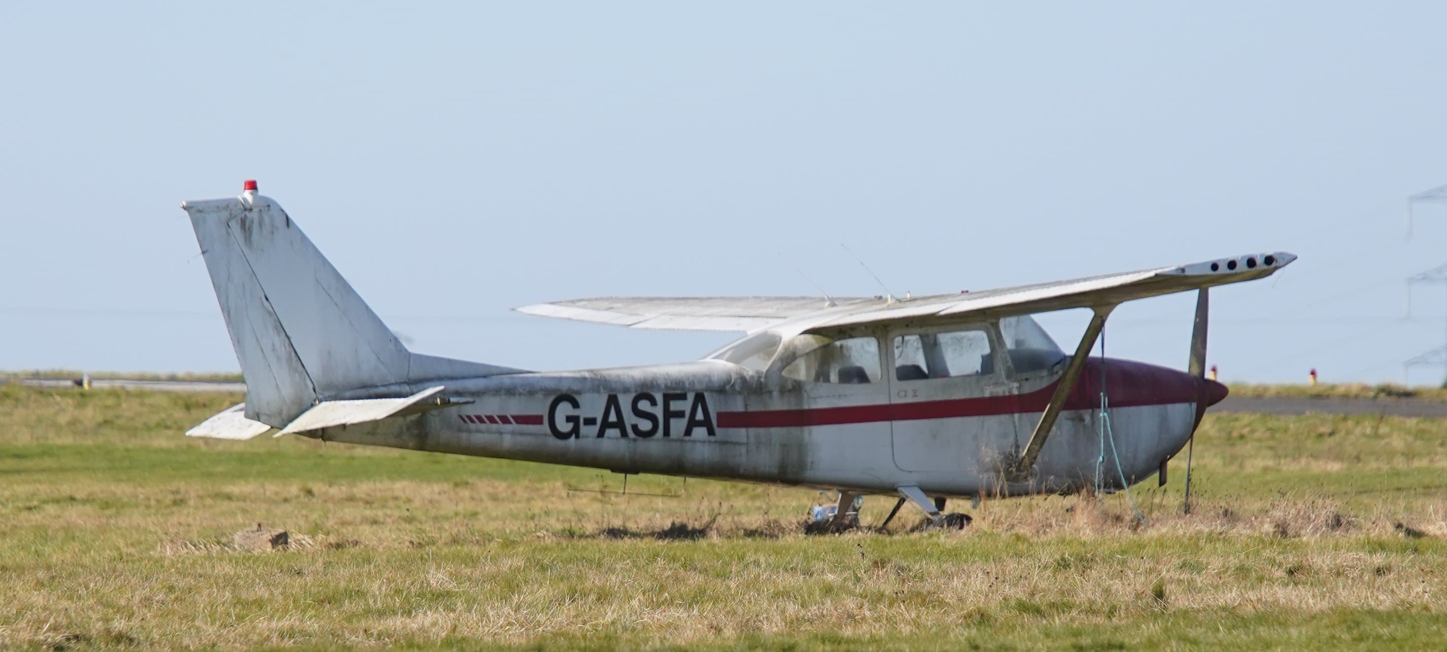 A weathered Cessna 172D Skyhawk parked in a field