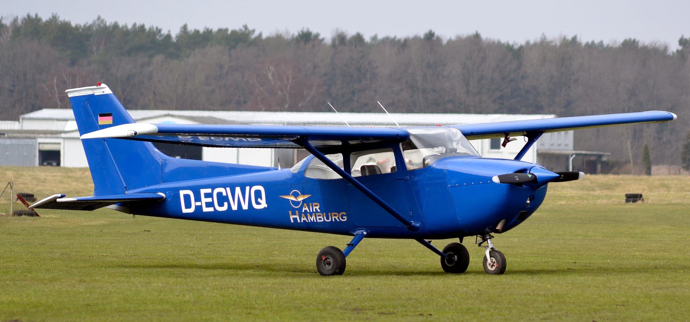A Cessna 172 Skyhawk in a deep blue livery on a grass airfield