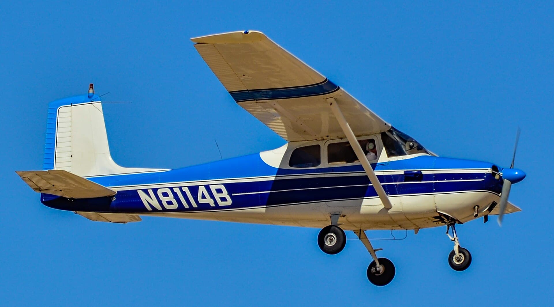 A 1957 straight-tail Cessna 172 in flight