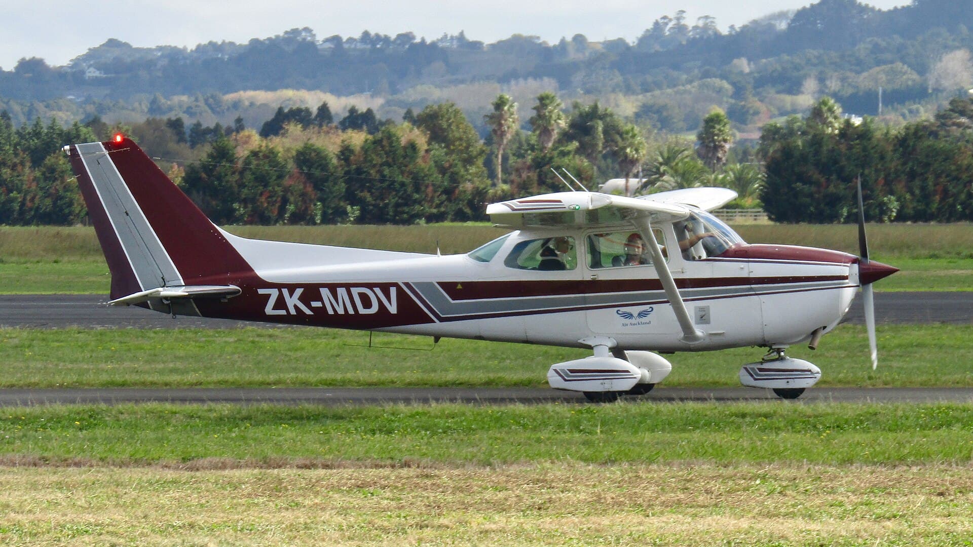 A Cessna 172 in side profile at Ardmore, New Zealand, showing the strut-braced high wing, the tapered spring-steel main gear legs and the wrap-around Omni-Vision rear window