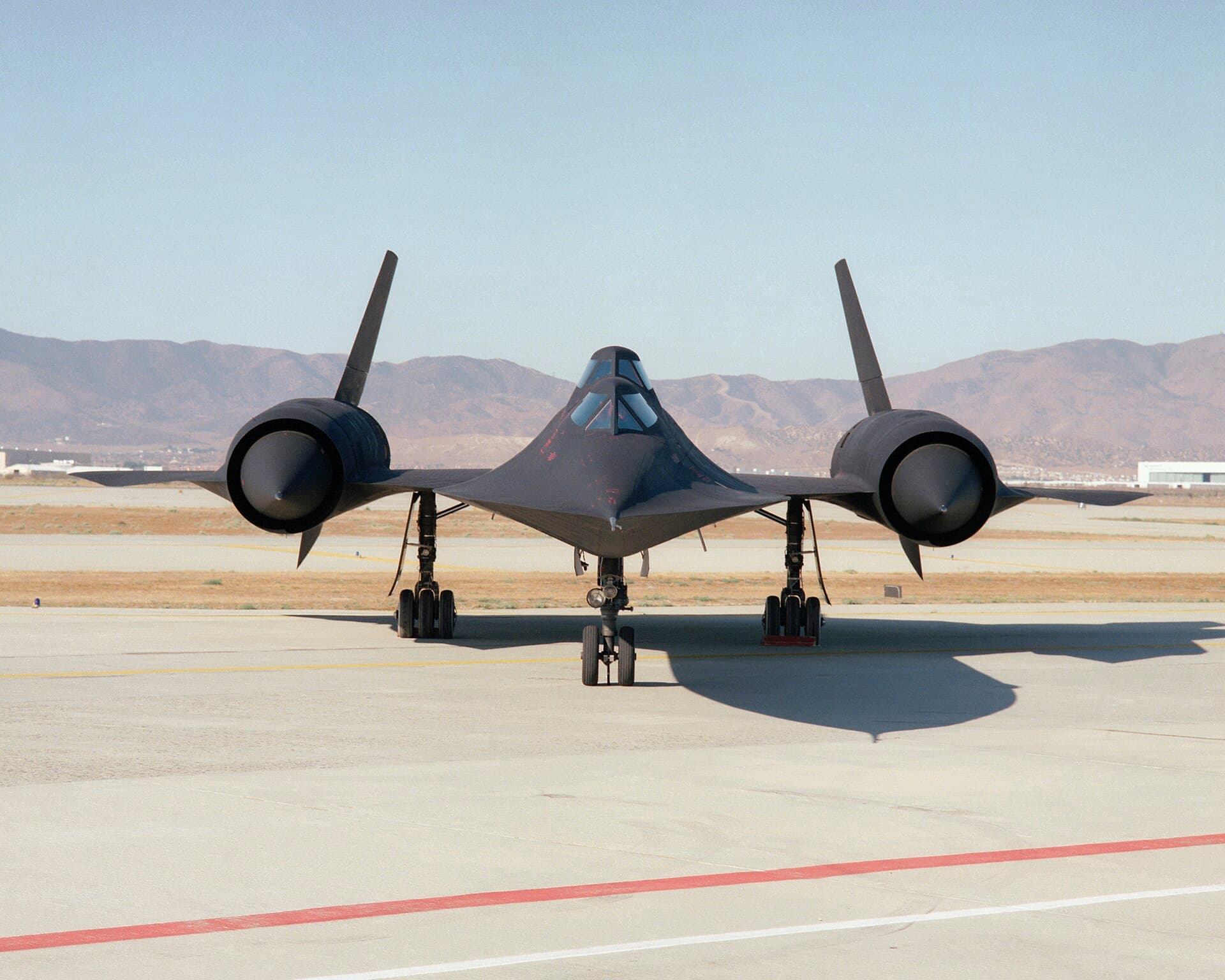 Head-on view of NASA's SR-71B trainer parked on the ramp, showing the raised rear instructor cockpit and both engine inlets