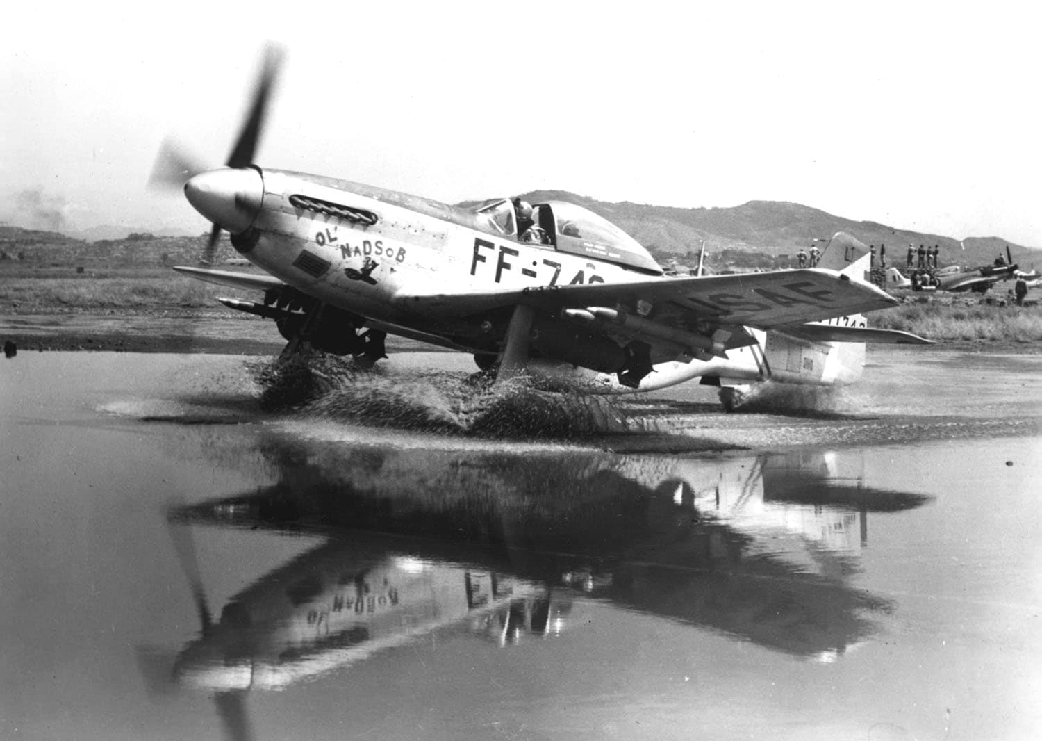 An F-51 Mustang of the United States Air Force parked in a puddle at a forward airstrip during the Korean War