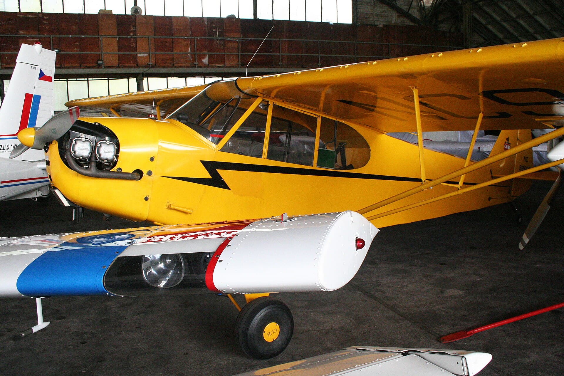 Un Piper J.3C-65 Cub jaune, immatriculé NC98689, stationné sur l'herbe
