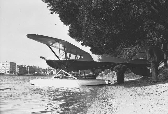 A float-equipped Taylorcraft taxiing on a lake
