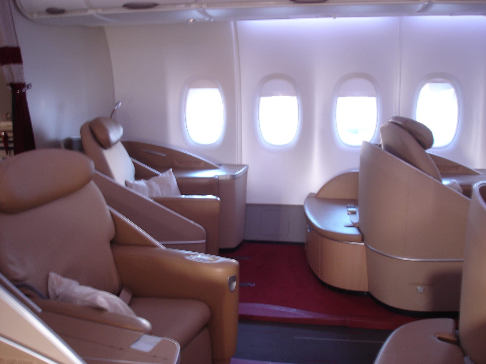 The La Première first class cabin aboard an Air France Airbus A380, with leather seats over red carpet.