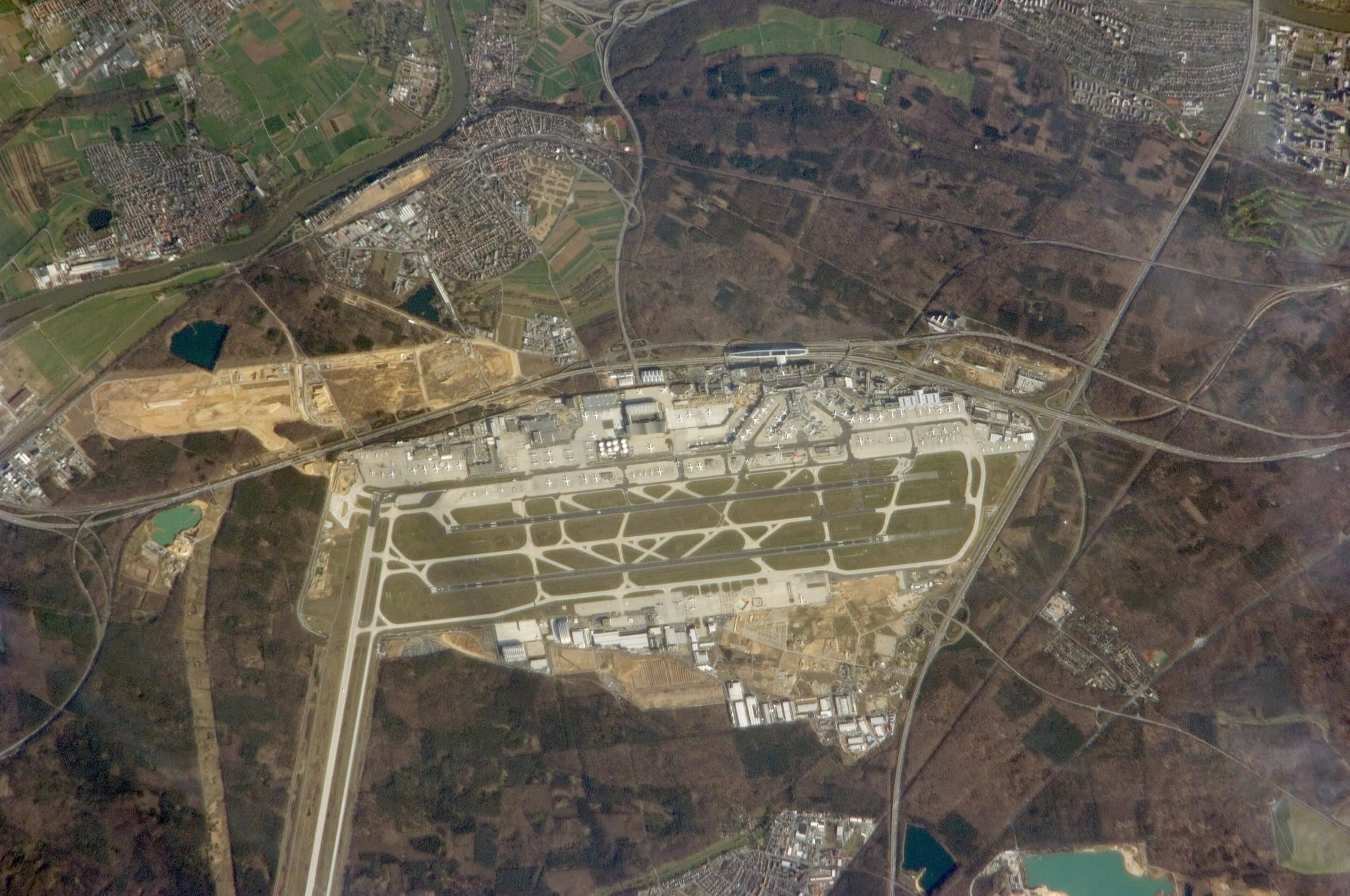 L'aéroport de Francfort vu à la verticale en 2010 : les pistes parallèles, les aérogares entre elles et la piste 18 Ouest qui traverse la forêt du nord au sud