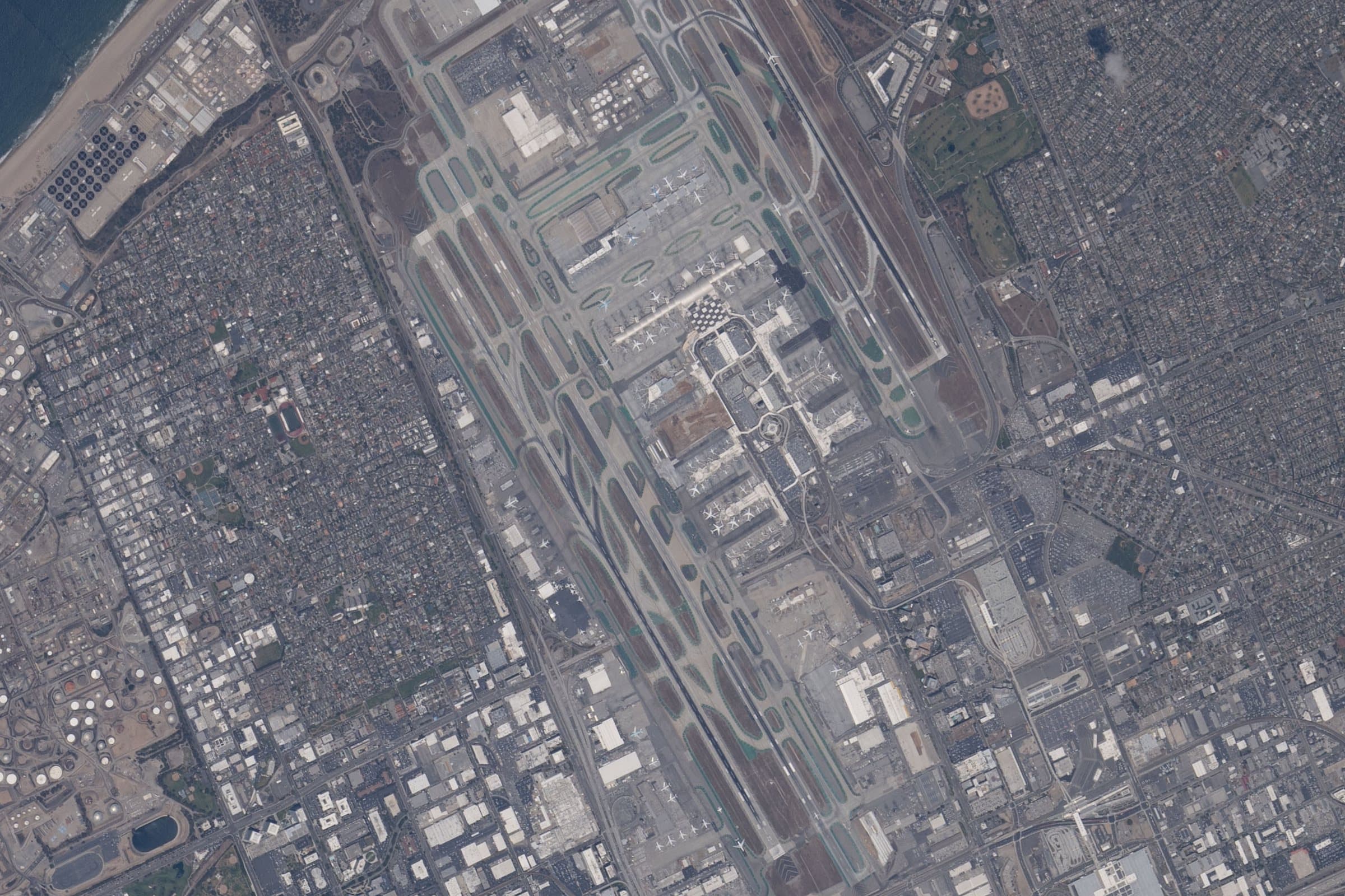 LAX vu à la verticale depuis la Station spatiale internationale en mai 2026 : deux paires de pistes parallèles orientées est-ouest, et le U des aérogares entre elles