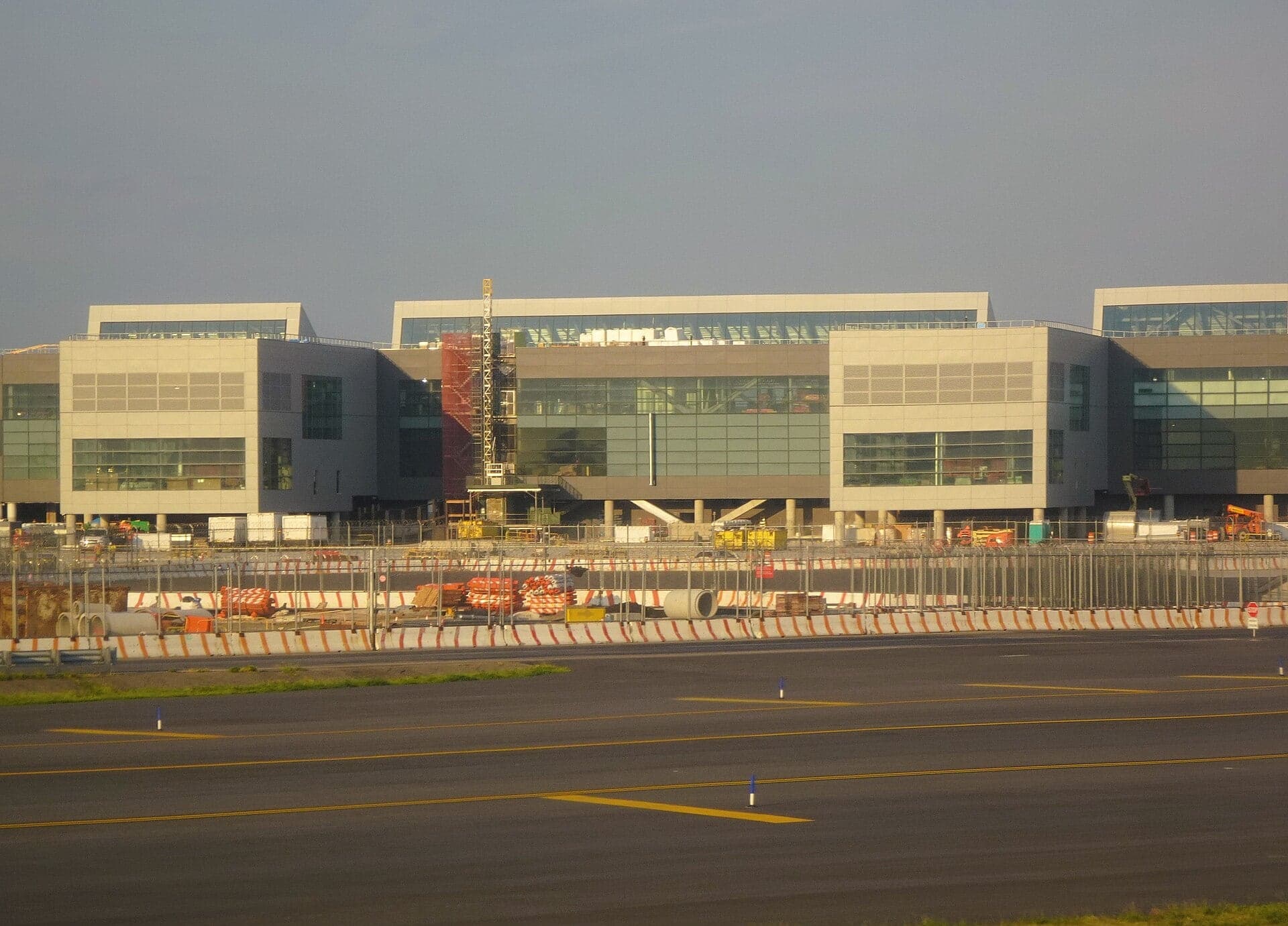 The New Terminal One under construction in August 2025, its multi-storey frontage behind site hoardings