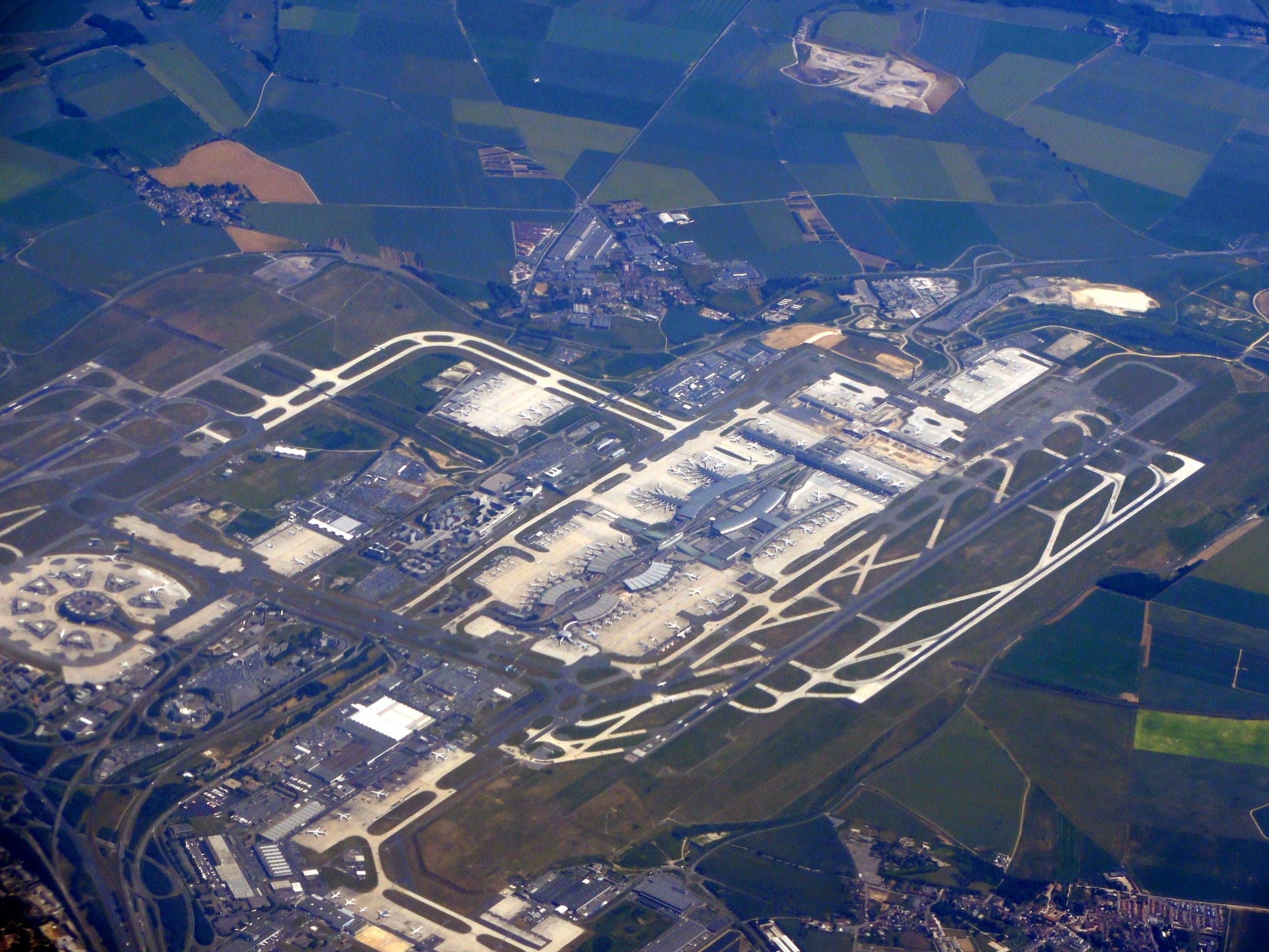 Paris-Charles-de-Gaulle vu du ciel, la zone des aérogares au milieu du terrain, les doublets de pistes de part et d'autre