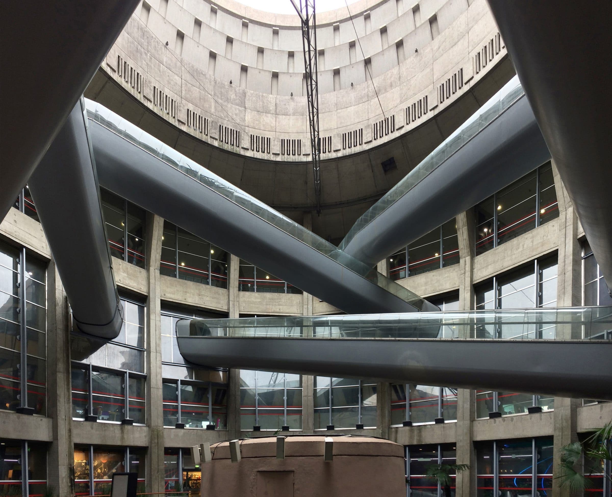 The interior of Terminal 1: escalators crossing the hollow centre of the concrete drum inside transparent tubes