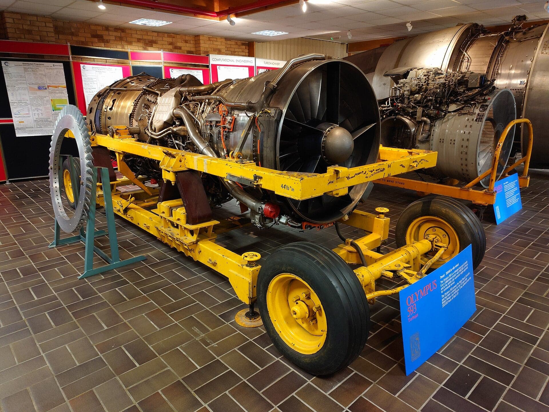 An Olympus 593-602B on a yellow stand in the Whittle Building at Cranfield University