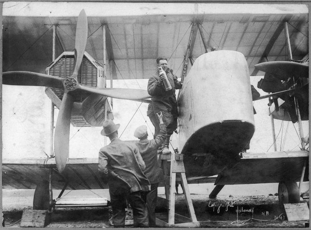 John Alcock rangeant les provisions dans le poste du Vimy avant le vol