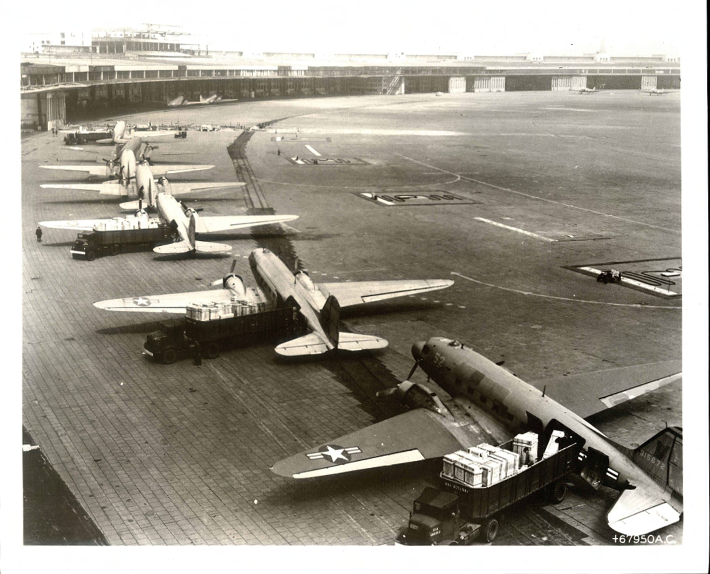 Des C-47 dans la file de déchargement à Tempelhof, transportant aussi bien des caisses de moteurs que des bouteilles de lait