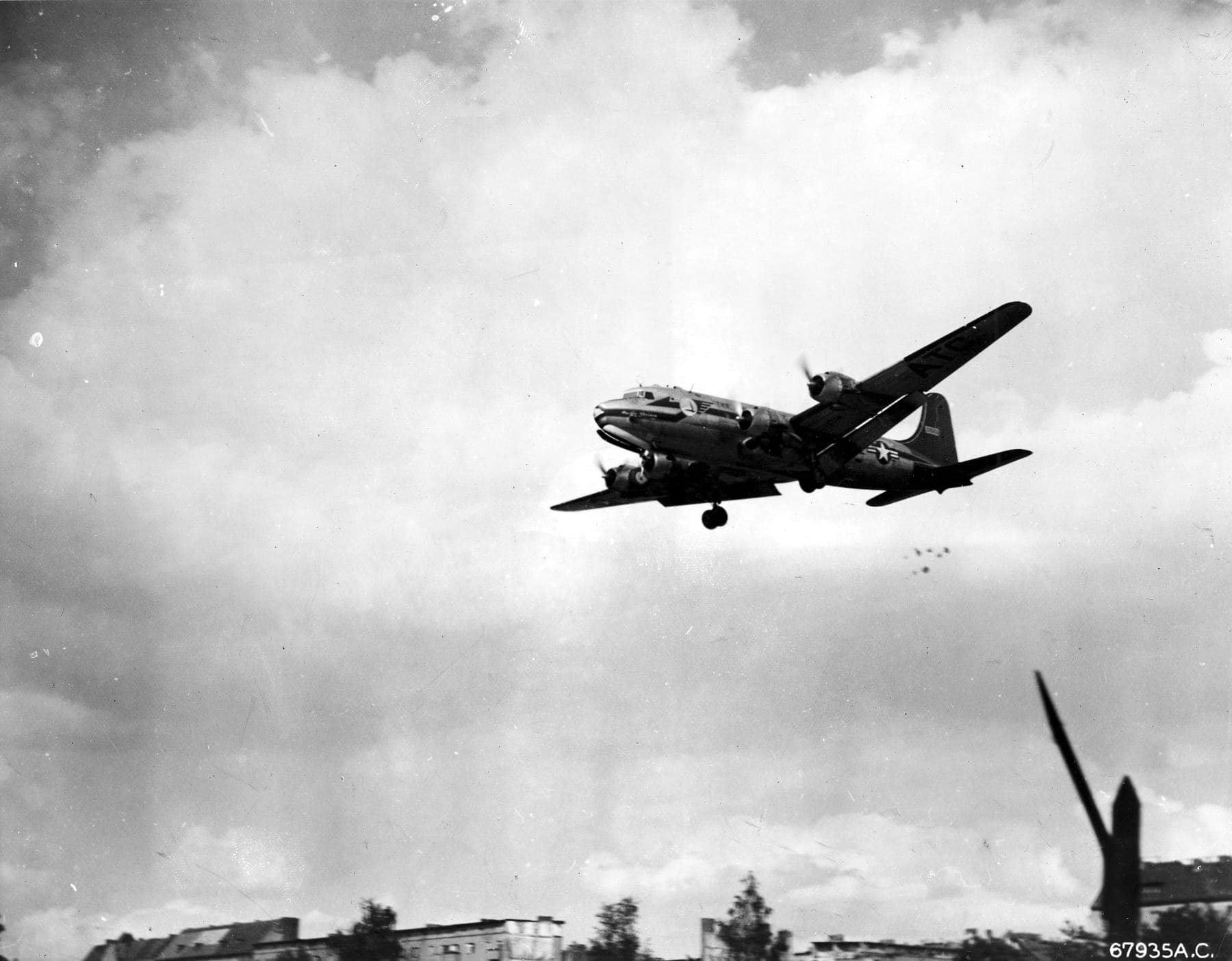Un C-54 en approche de Berlin, les petits parachutes de bonbons de « Little Vittles » sous sa queue