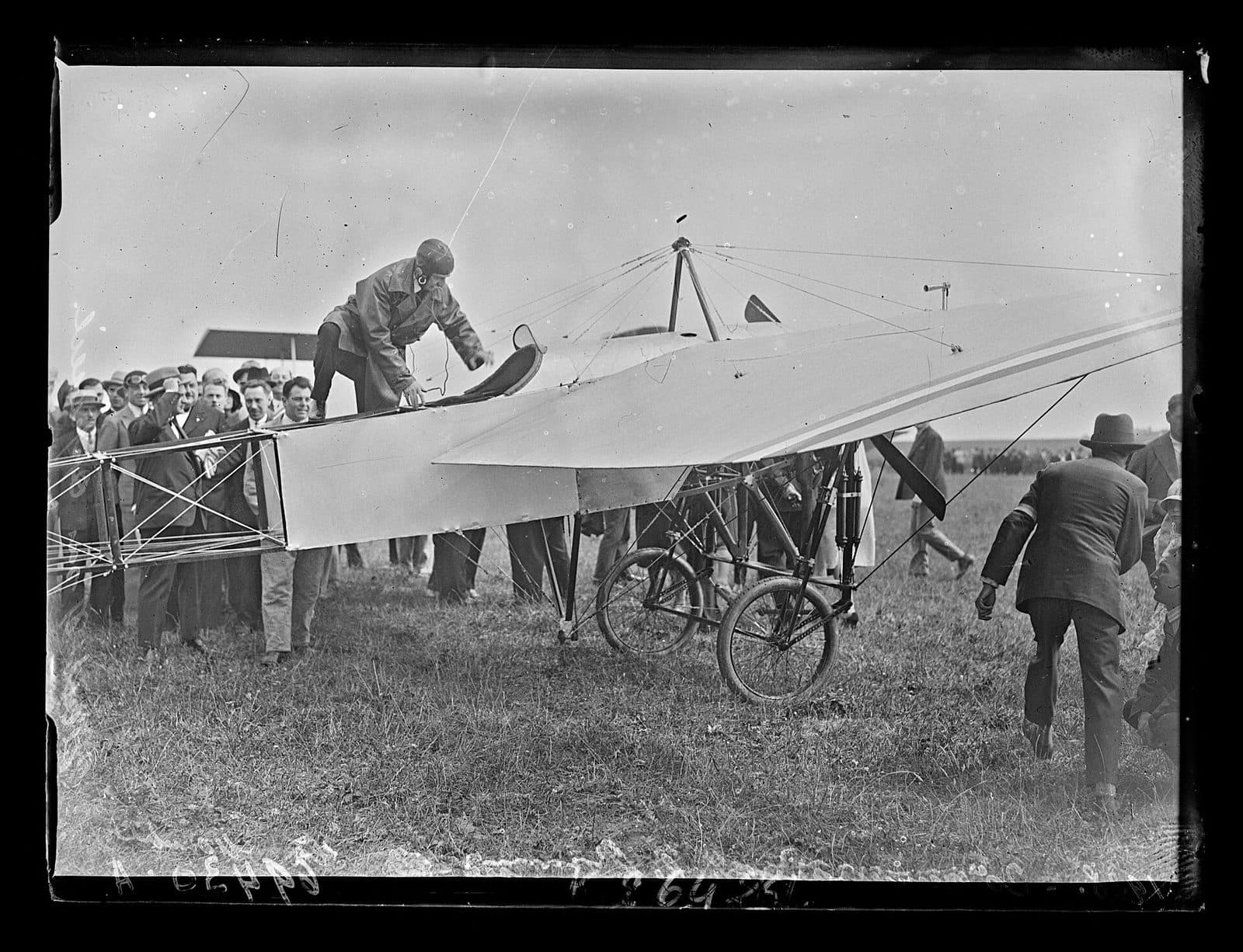 Louis Blériot assis aux commandes d'un monoplan à Calais pour le vingtième anniversaire de la traversée.