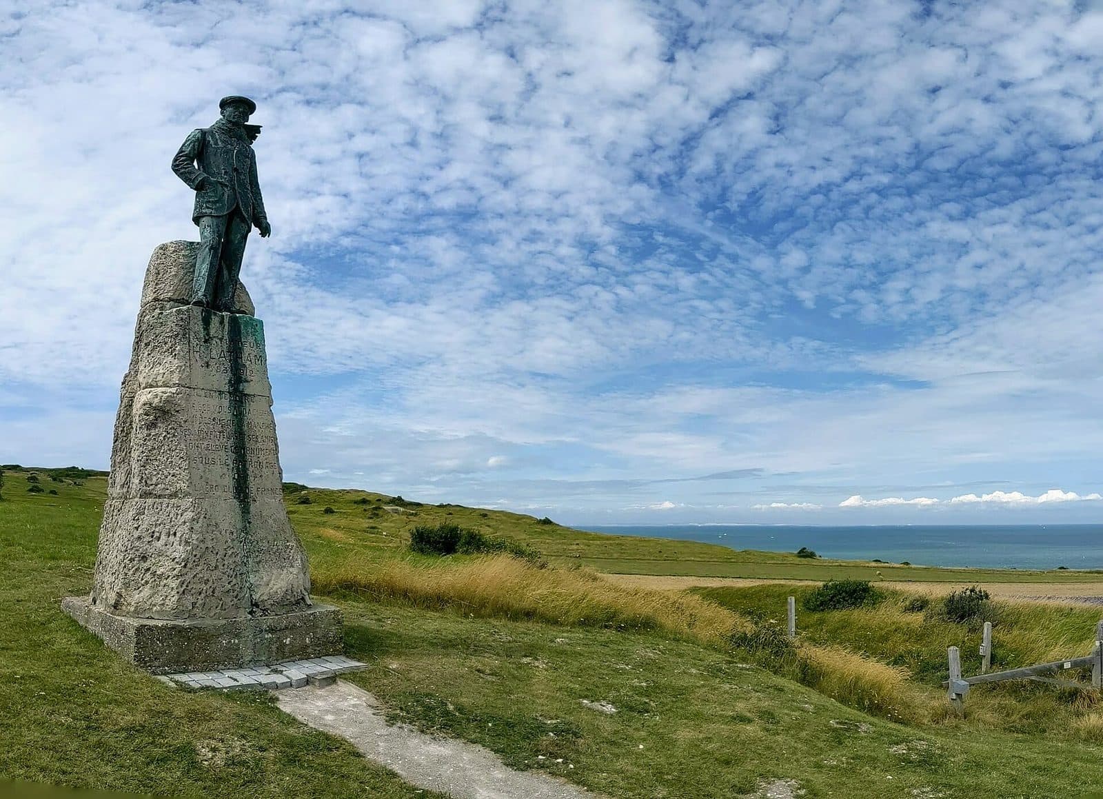 La statue d'Hubert Latham sur un socle de pierre, sur la lande des falaises près de Sangatte, la Manche en arrière-plan.