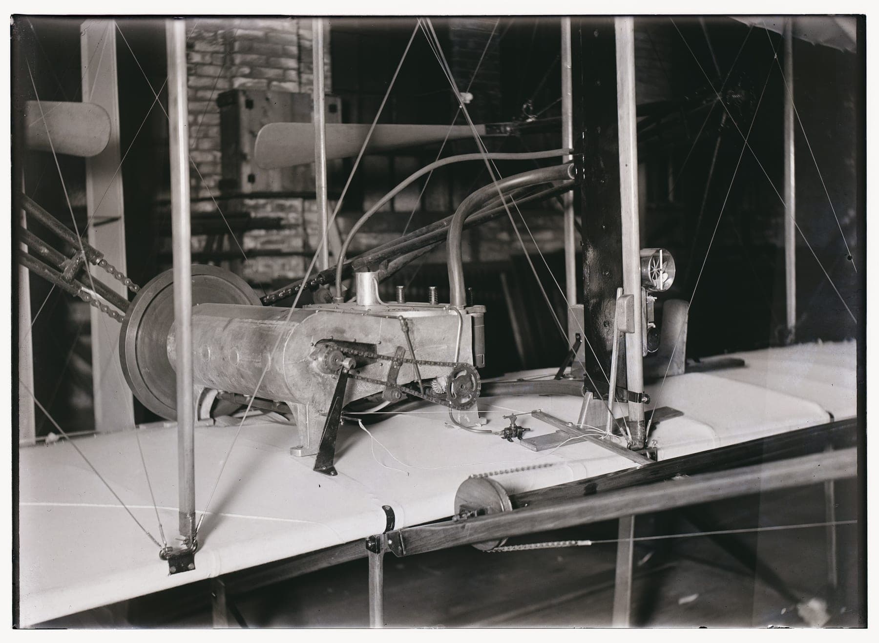 La section centrale du Flyer de 1903 photographiée en atelier : le moteur quatre cylindres, les transmissions par chaîne et le berceau du pilote.