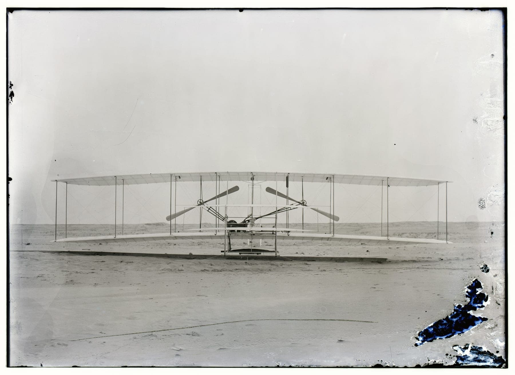 Le Flyer de 1903 photographié de face : les deux hélices propulsives, les tubes de chaîne et les patins.