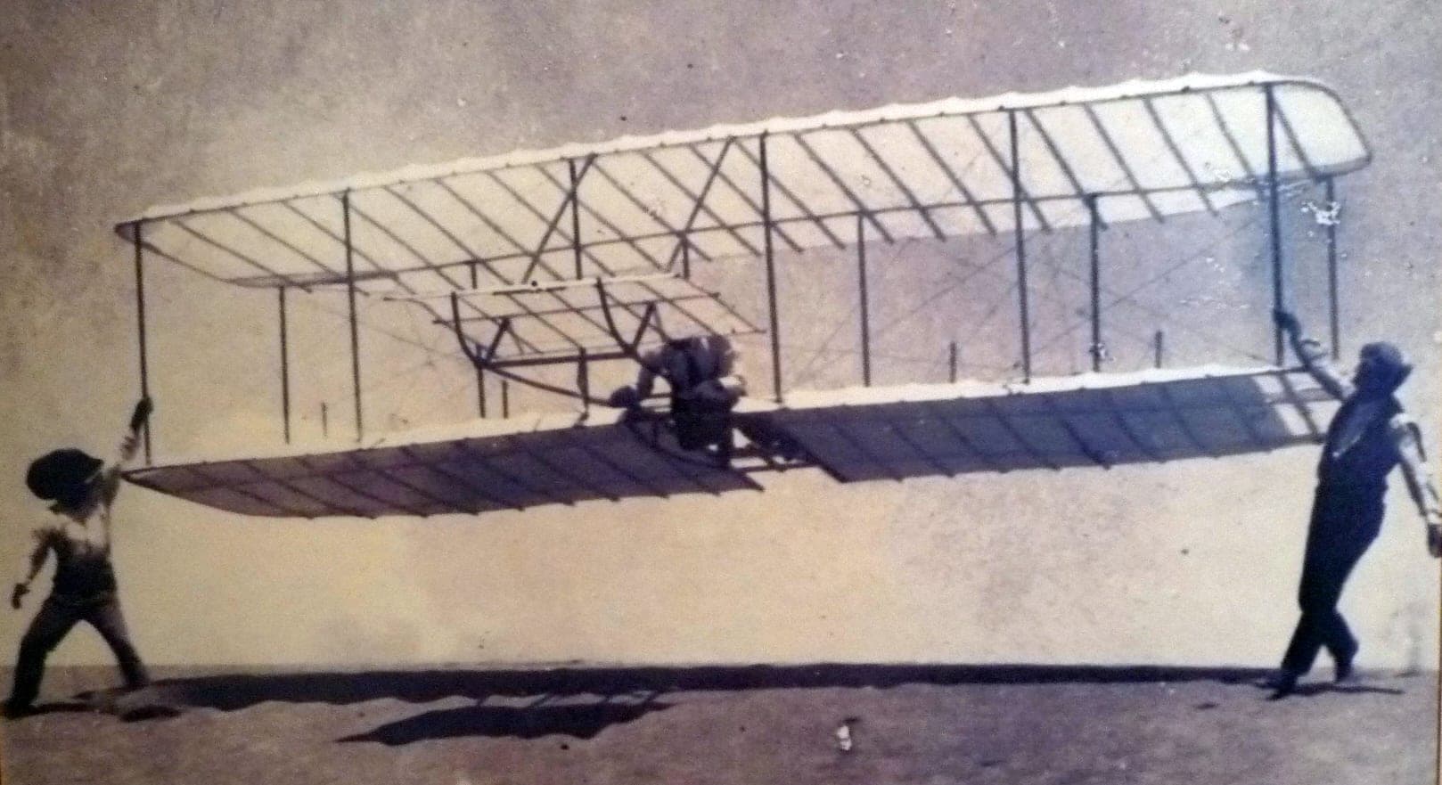 Wilbur Wright lancé dans le planeur de 1901 par William et Dan Tate, un homme à chaque extrémité d'aile.