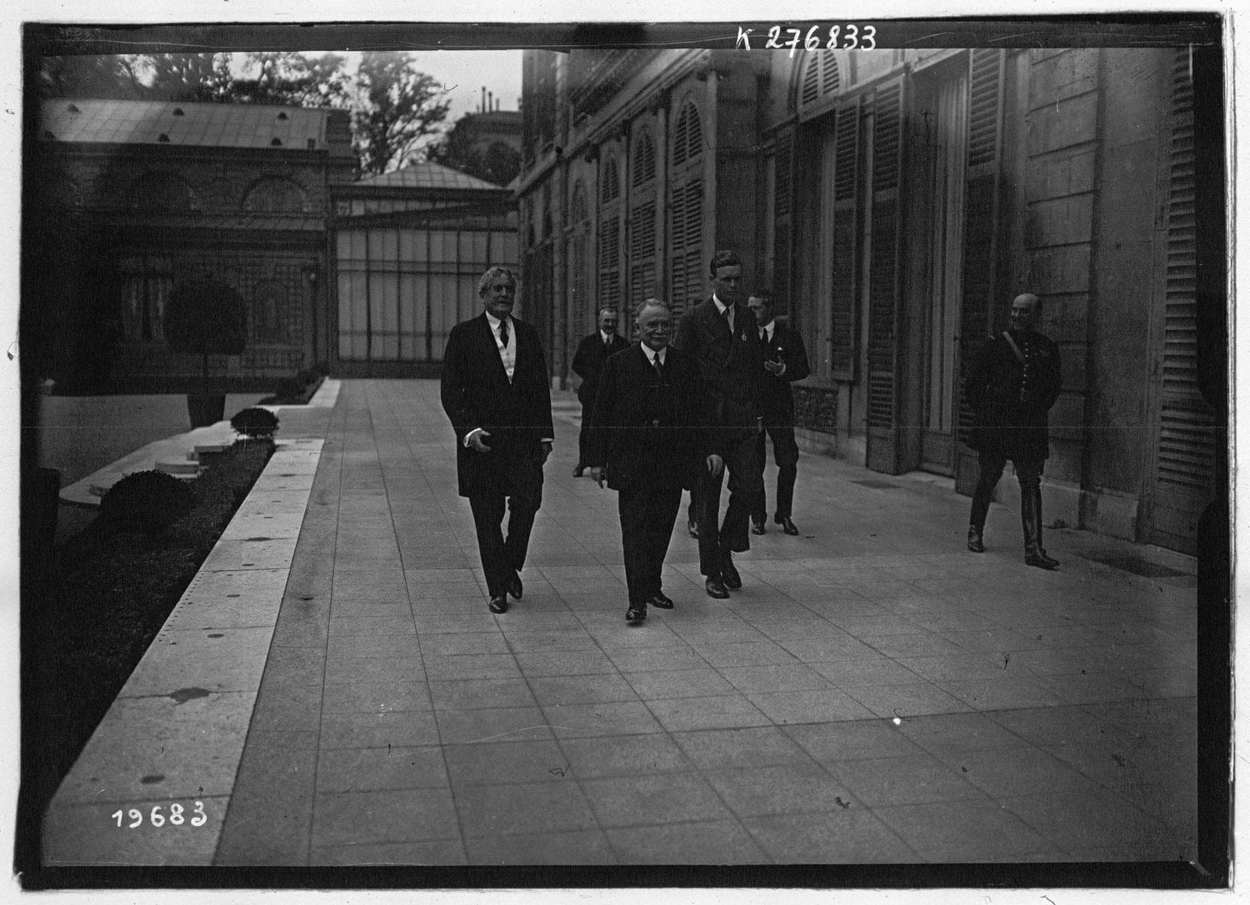 Lindbergh, grand et tête nue, marchant aux côtés de personnalités françaises à Paris dans les jours qui suivirent le vol.