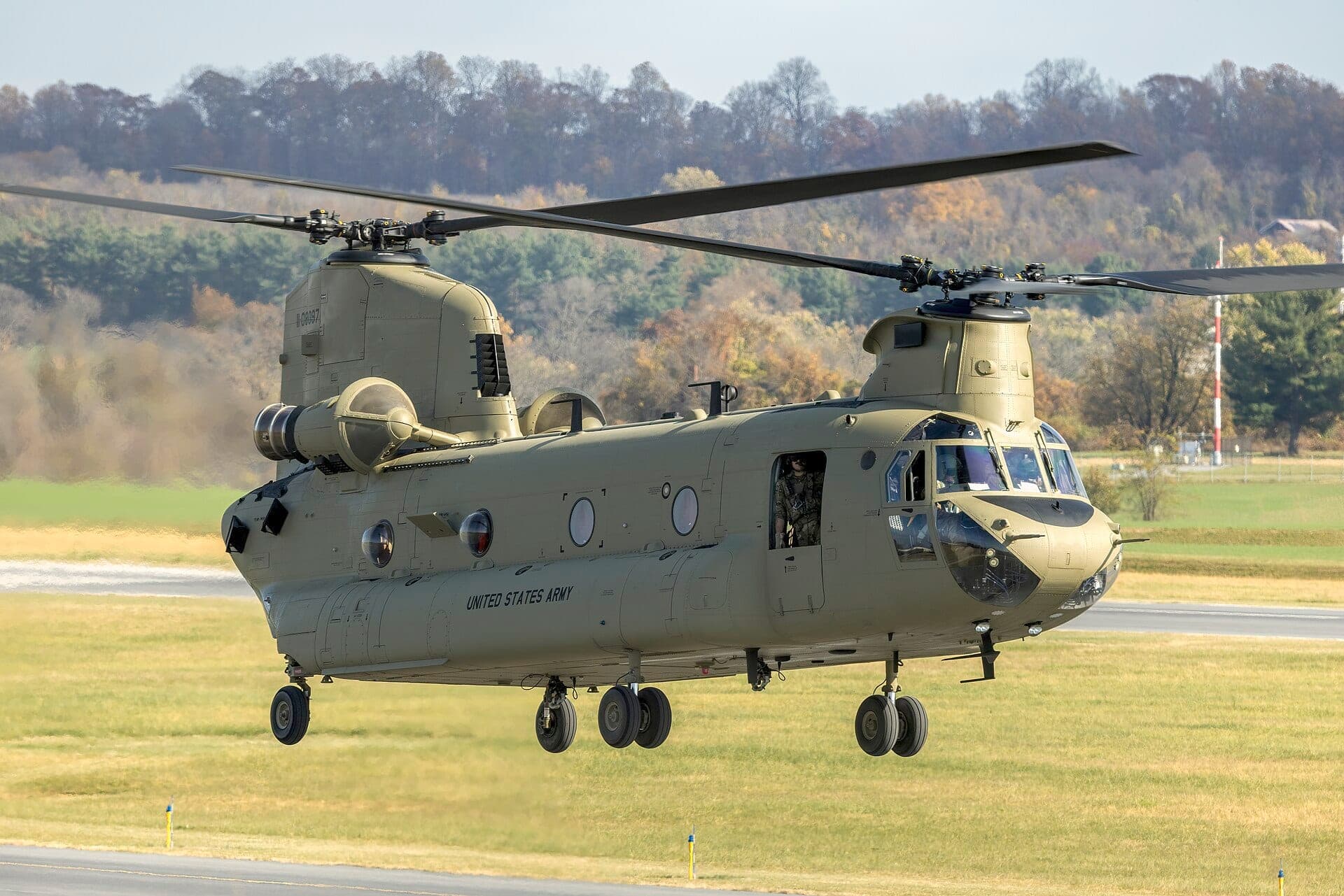 Un Boeing CH-47F Chinook de l'armée américaine en vol stationnaire, ses rotors en tandem en rotation