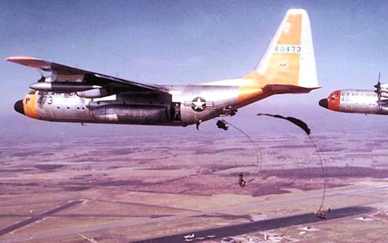 A Lockheed C-130A Hercules dropping parachute loads from its rear ramp in 1959