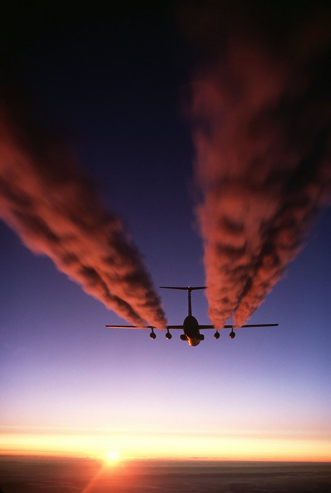 A Lockheed C-141B Starlifter trailing four contrails over Antarctica during Operation Deep Freeze