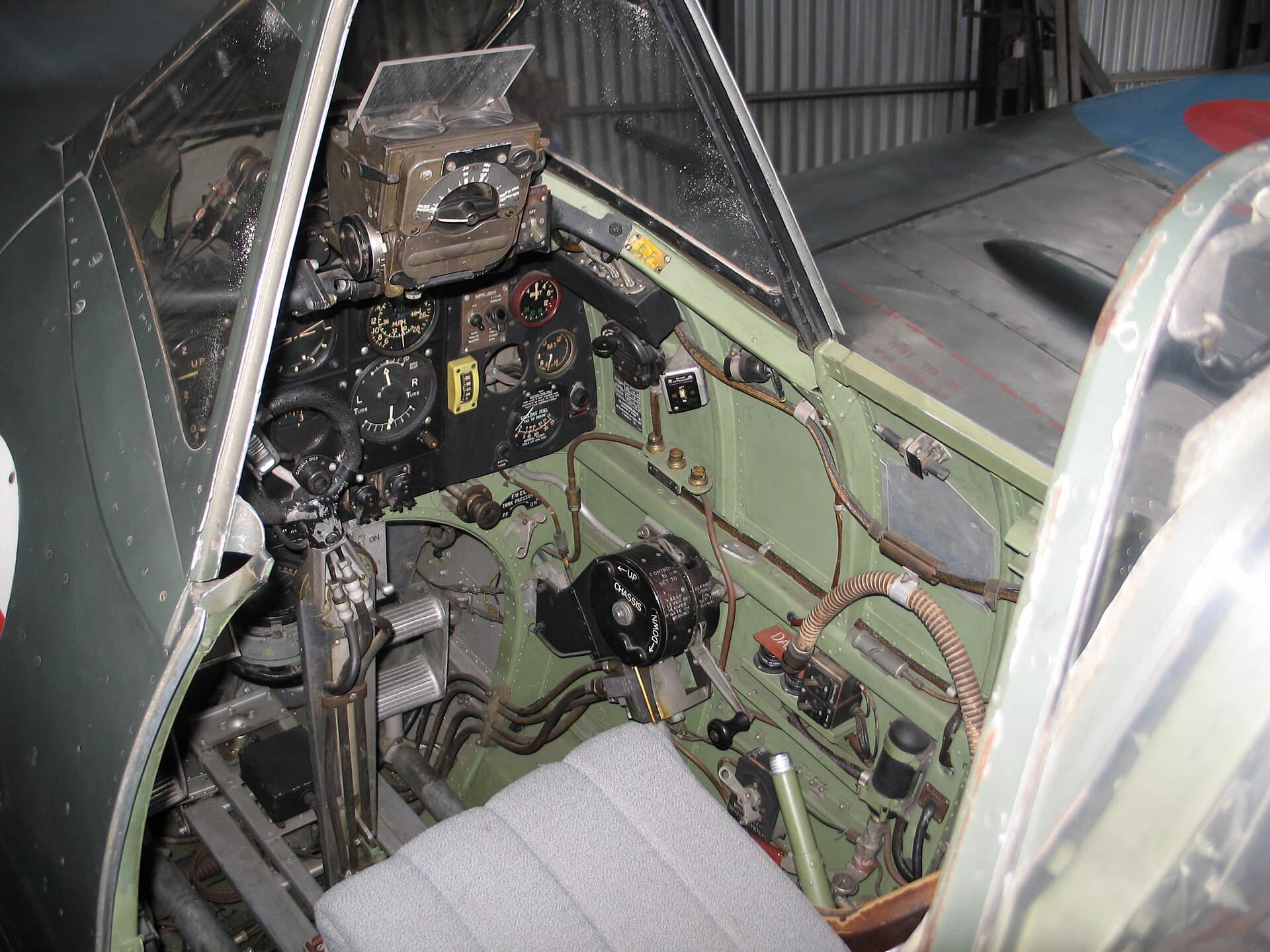 Le cockpit exigu d'un Spitfire conservé, montrant le tableau de vol aux instruments et le manche à balai