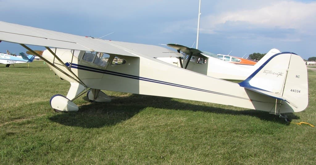 A Taylorcraft BC-12D in flight, showing its flat-sided fuselage and rounded tail