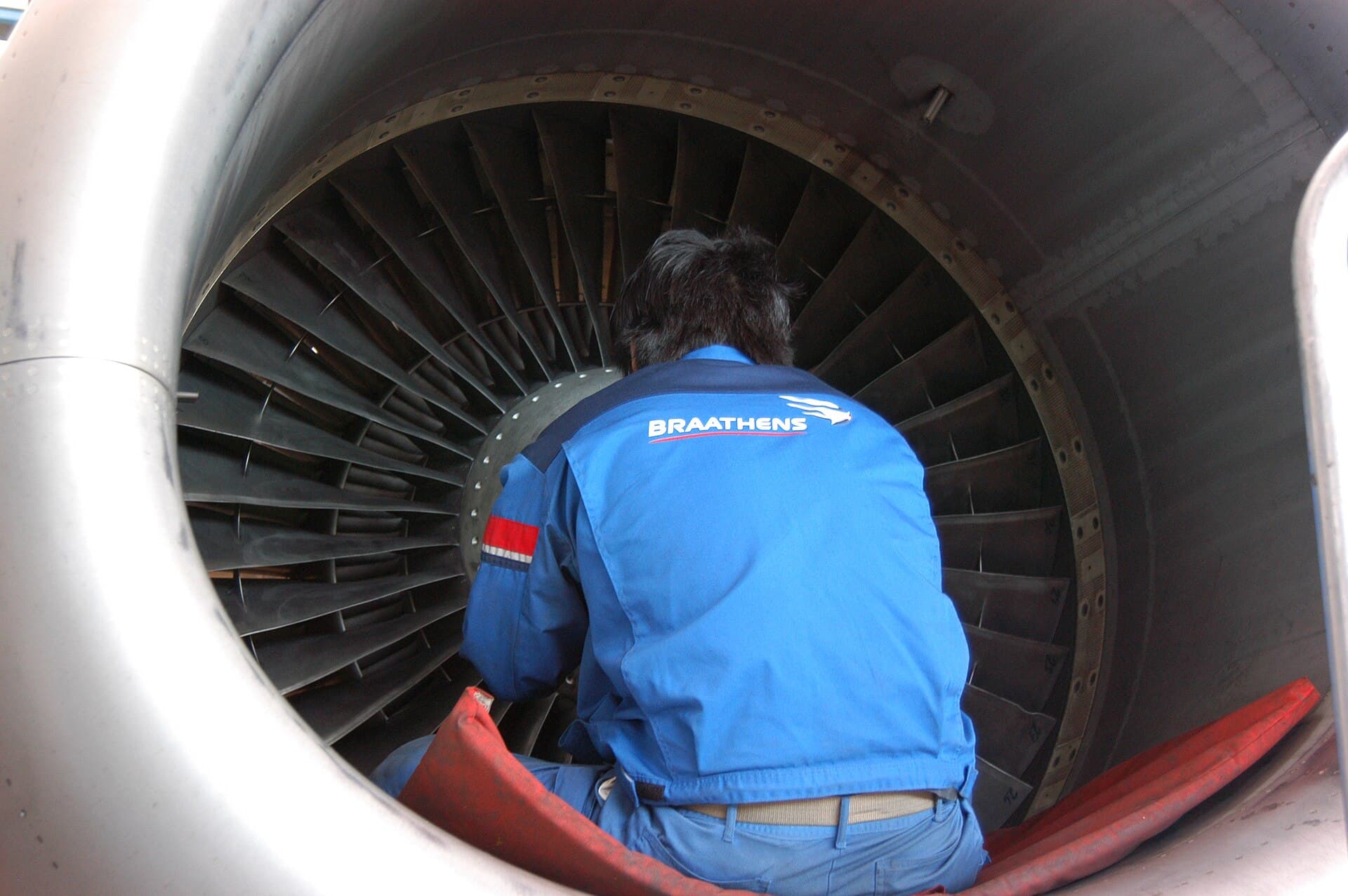 A Braathens technician inspecting the fan of a CFM56 from inside the intake
