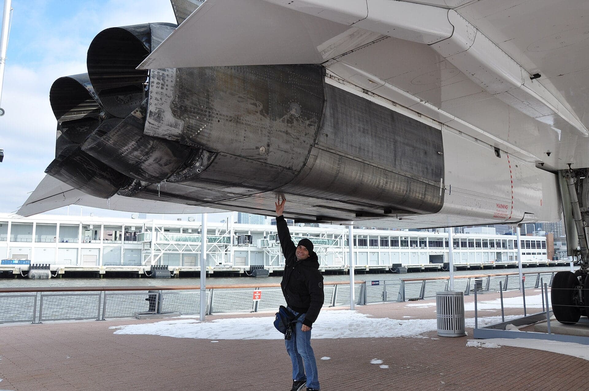 A visitor reaches up to the rear of an engine nacelle on Concorde G-BOAD at the Intrepid Museum, New York, where the reheat jet pipe ran