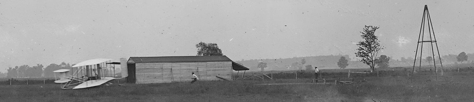 Le début du premier vol de 1905 à Huffman Prairie : Orville aux commandes près du hangar, avec la catapulte à contrepoids et derrick qui remplaçait la brise de mer.